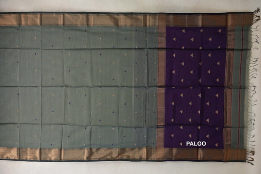 Maheshwari silk cotton saree spread flat, with a sage green body, tiny triangle motifs, patterned dark sage green borders and a deep purple pallu with tassels.
