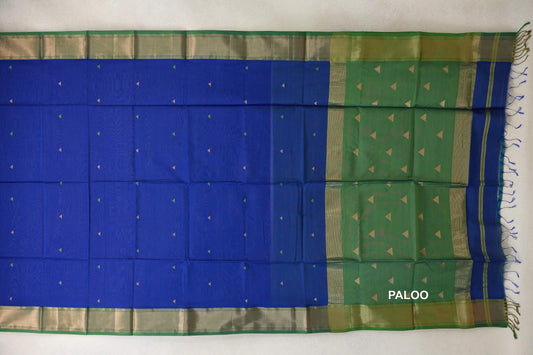 Maheshwari silk-cotton saree spread flat, with a royal blue body, small triangle motifs, leaf green borders and pallu, and tassels.