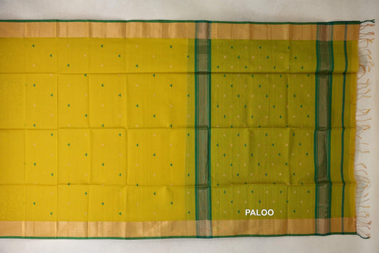 Maheshwari silk cotton saree laid flat, with a bright lemon yellow body, leaf green pallu, small triangle motifs, gold-toned borders and tassels.