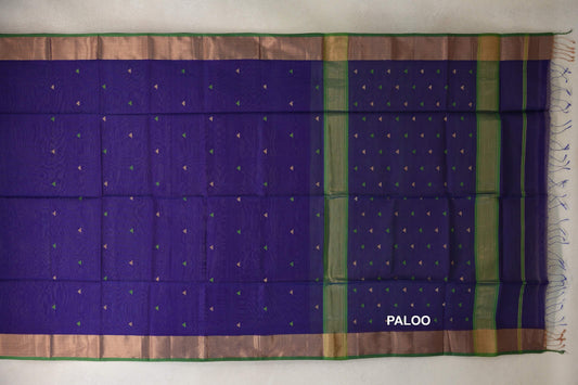 Deep violet Maheshwari silk cotton saree laid open, showing small green and gold triangles, a striped pallu, green-edged borders and tassels.