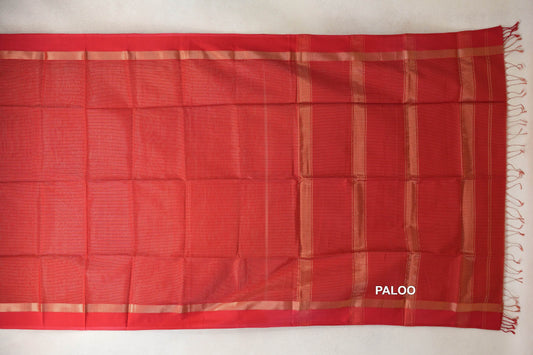 Red Maheshwari silk-cotton saree laid flat, showing a plain body, narrow gold-toned borders and a striped pallu with red tassels.