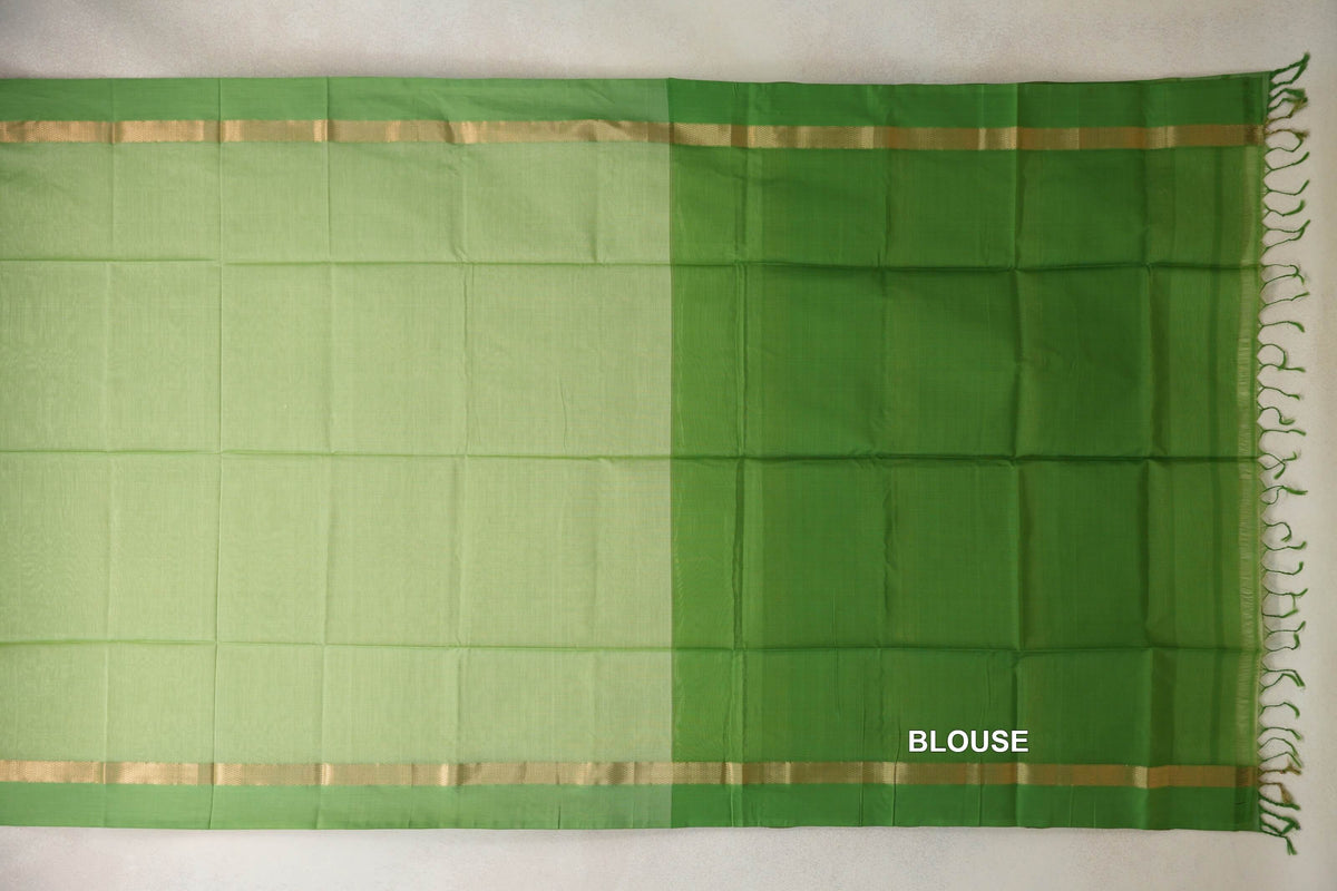 Laid-flat pista green silk cotton saree with gold-striped leaf green borders, a leaf green blouse section on the right, and tassels.