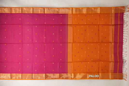 Rani pink Maheshwari silk cotton saree laid flat, with scattered small accents, deep orange borders and pallu, and tassels at the end.