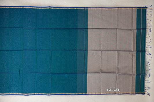 Maheshwari silk cotton saree laid flat, showing a peacock green body, peacock blue selvedge borders and a silver beige pallu with blue tassels.
