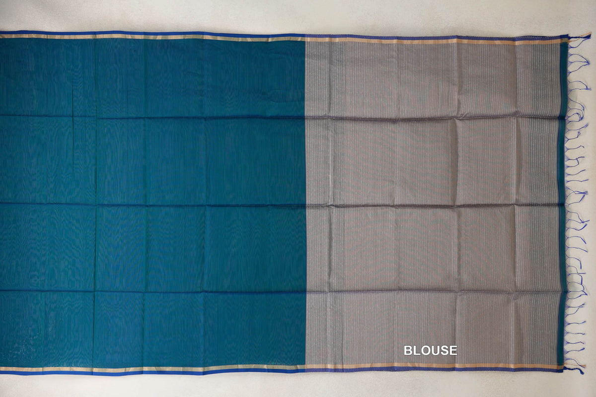 Maheshwari silk cotton saree laid flat, with a peacock green body, peacock blue selvedge borders and a striped silver beige blouse section with tassels.