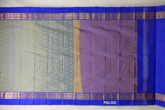 Spread-out lightweight Kanchipuram silk saree with a yellowish green body, small gold motifs, royal blue borders and a lattice-patterned pallu.