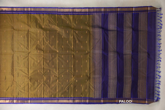Unfolded olive green Kanchipuram silk saree with small gold-toned motifs, deep royal blue borders and a patterned blue pallu with tassels.