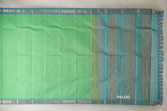 Lightweight Kanchipuram silk saree laid flat, with a mint green body dotted with gold motifs, light turquoise blue borders and a patterned pallu with tassels.
