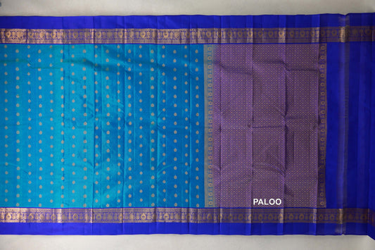 Light Weight Kanchipuram silk saree laid out, with a peacock blue body dotted in gold, royal blue patterned borders and a gold lattice pallu.