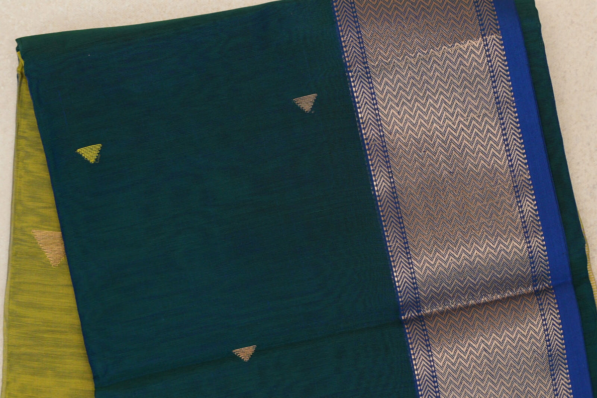 Folded peacock green Maheshwari silk cotton saree with small gold triangular motifs and a broad royal blue border with metallic chevrons.
