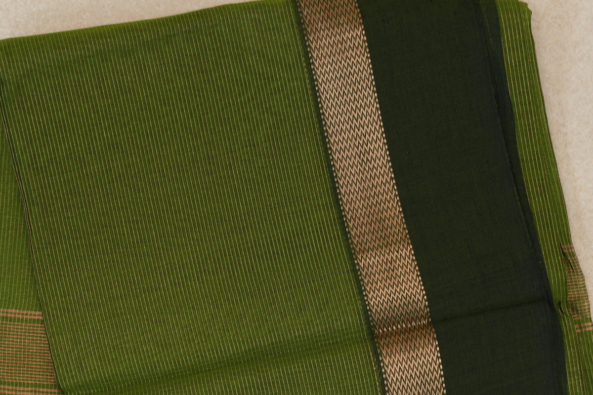 Folded Maheshwari silk cotton saree showing a finely striped olive green body, a woven chevron band and a deep forest green border.
