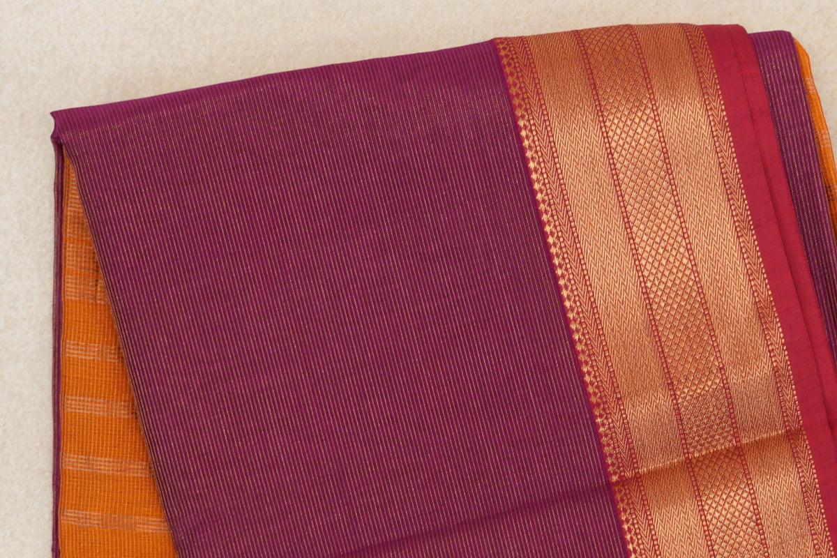 Folded deep magenta Maheshwari silk cotton saree with fine stripes, a patterned orange-gold border, rani pink edge and deep orange fabric beneath.