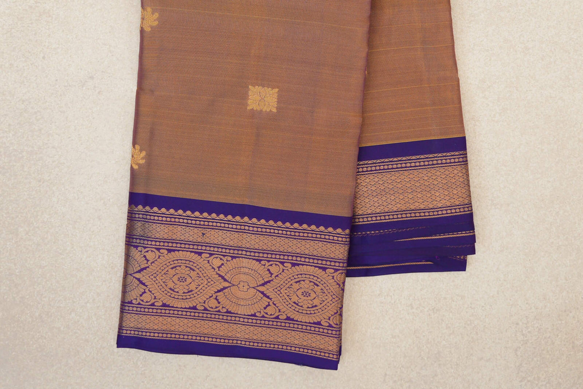 Folded lightweight Kanchipuram silk saree showing a magenta and yellow body with small gold motifs and an ornate violet purple border.
