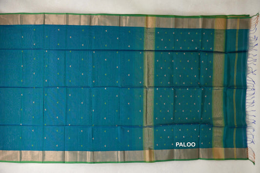 Peacock blue Maheshwari silk cotton saree laid open, with tiny triangle motifs, parrot green-edged borders and a striped pallu with tassels.