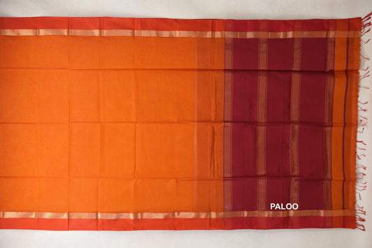Spread-out Maheshwari silk-cotton saree with a reddish orange body, orangish red borders, and a striped pallu with tassels.