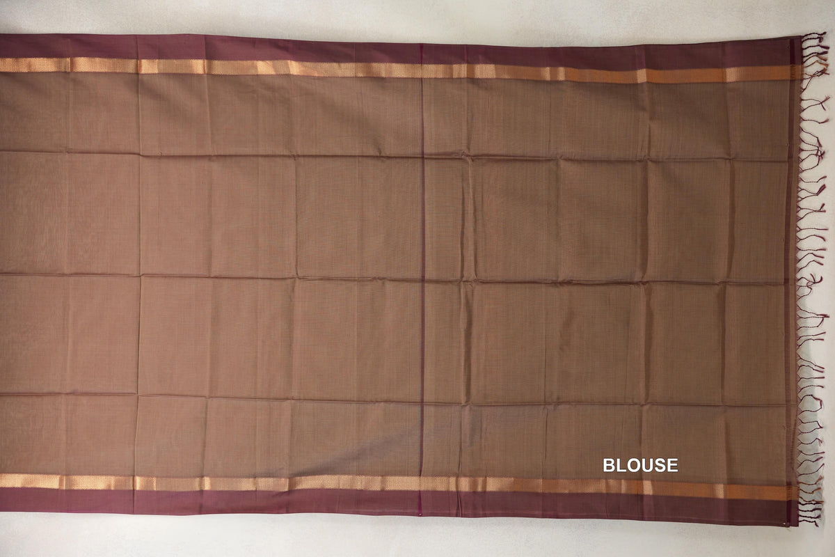 Laid-flat beige and magenta Maheshwari silk cotton blouse piece with magenta borders, gold-patterned stripes and tassels along one edge.
