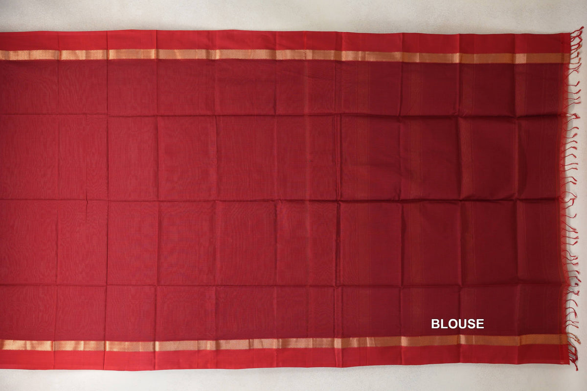 Deep red Maheshwari silk cotton blouse piece laid flat, with narrow gold-toned borders along the top and bottom and red tassels at one end.