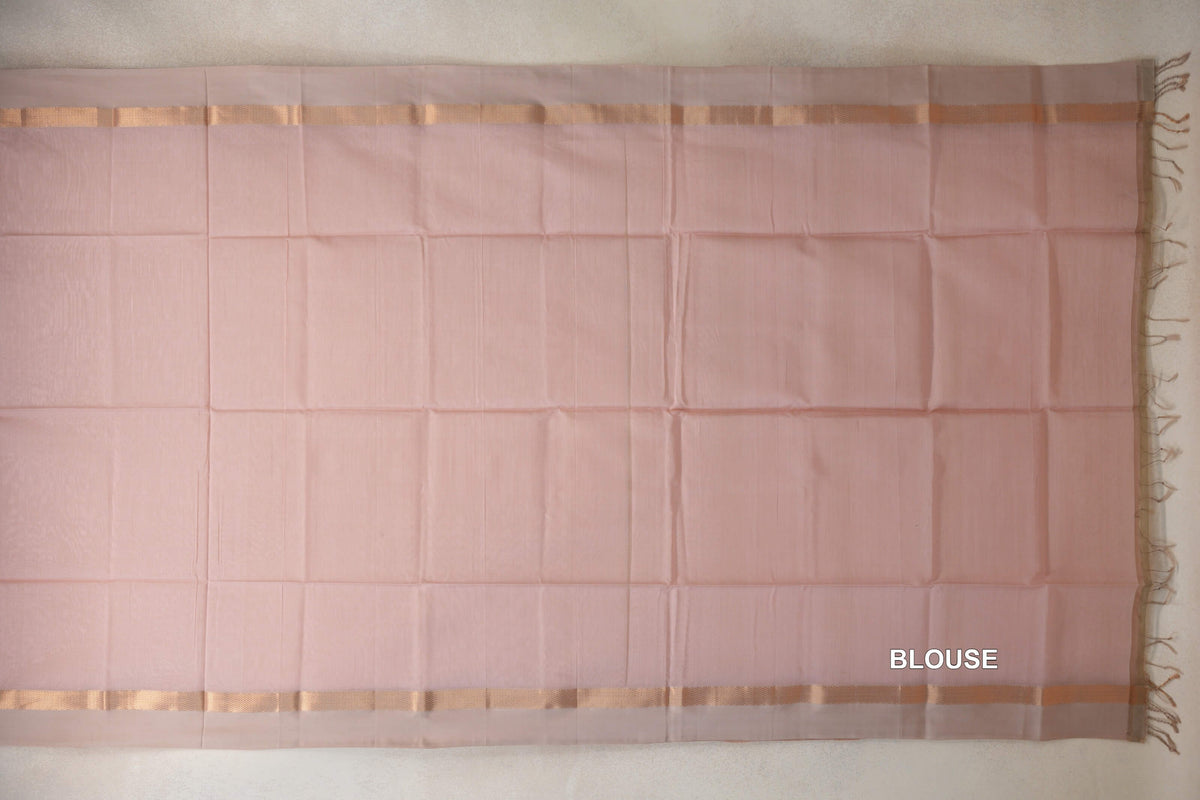 Blush pink silk cotton blouse fabric laid flat, with light sandal beige woven borders along the top and bottom and tassels at one end.
