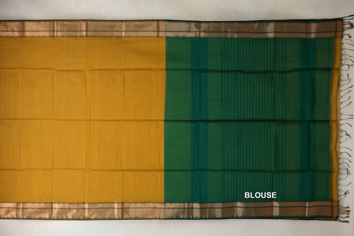 Maheshwari silk-cotton saree laid flat, showing a mustard yellow body beside a deep emerald green striped blouse section, with patterned borders and tassels.