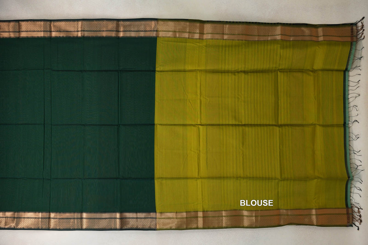 Maheshwari silk cotton saree laid flat, with a bottle green body beside an olive yellow blouse section, patterned borders and tassels at the right edge.
