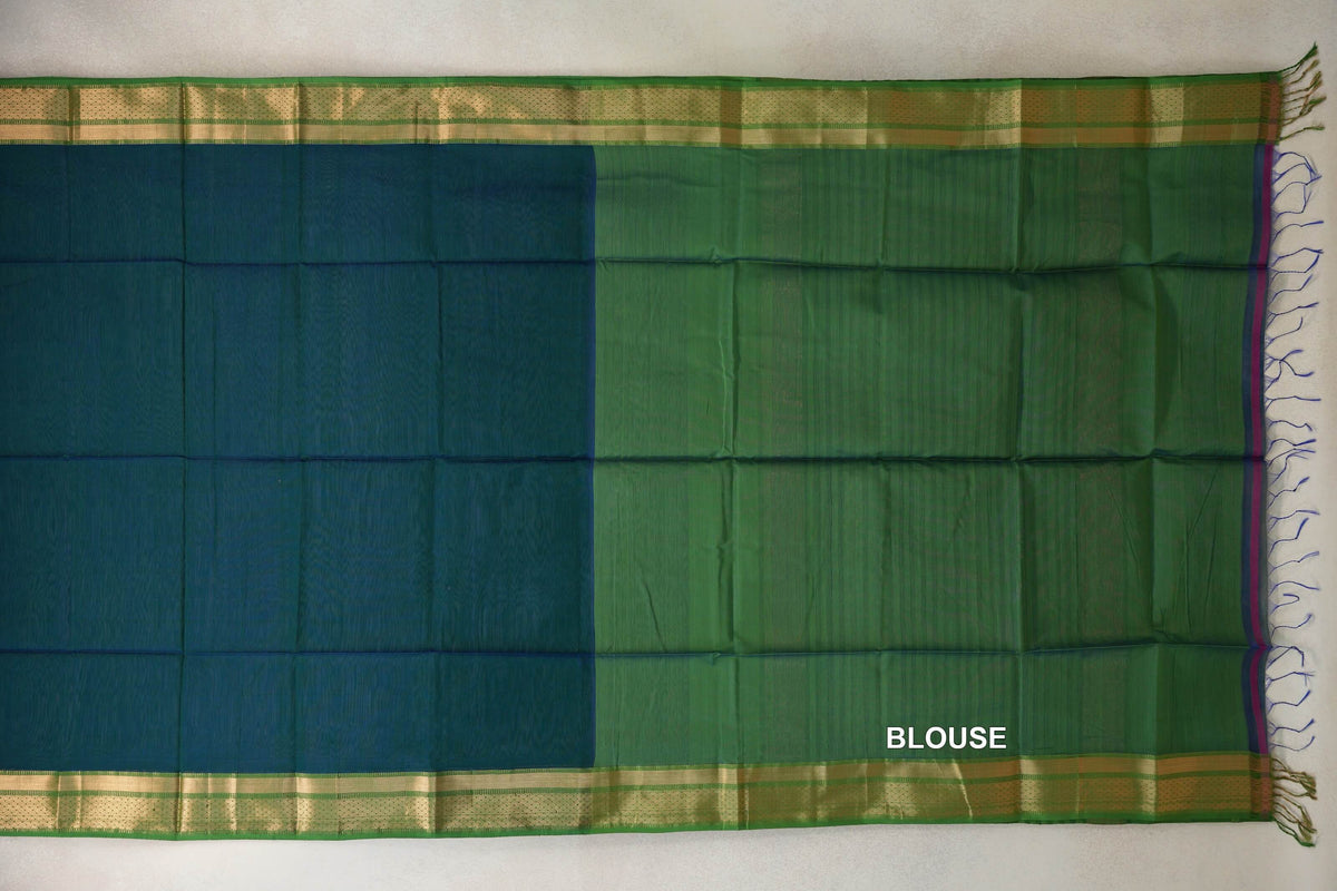 Maheshwari silk cotton saree laid flat, showing a peacock blue section beside a leaf green blouse section, with gold-coloured borders and tassels.