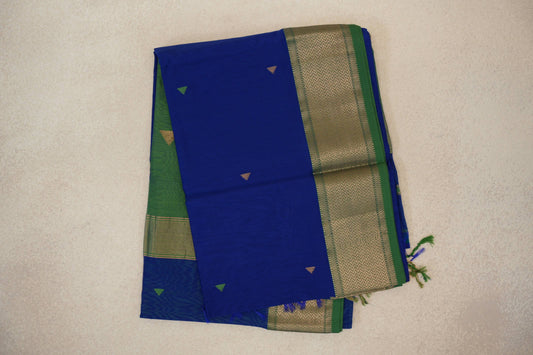 Folded royal blue Maheshwari silk-cotton saree with small green and gold triangles, a leaf green border with gold chevrons, and tassels.