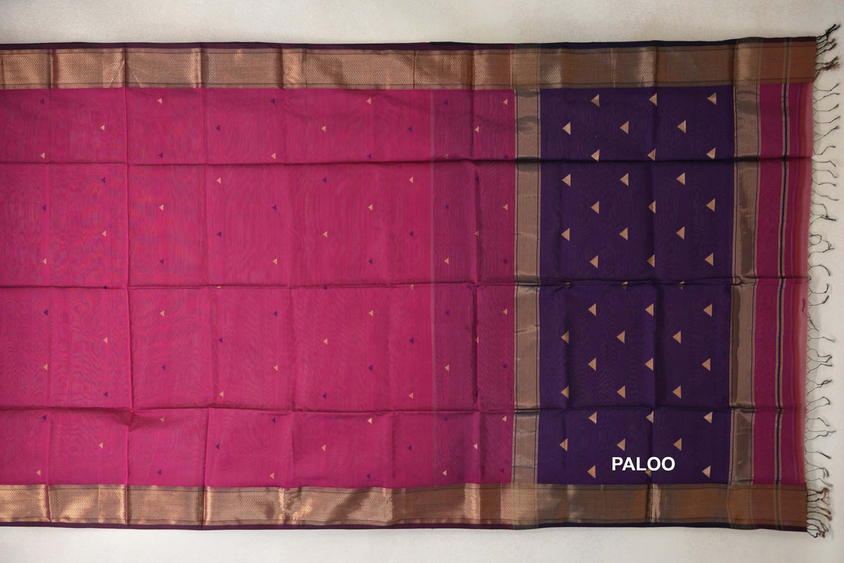Maheshwari silk cotton saree laid flat, with a Deep Rani Pink body, small triangle motifs, gold-toned borders and a Deep Purple pallu with tassels.