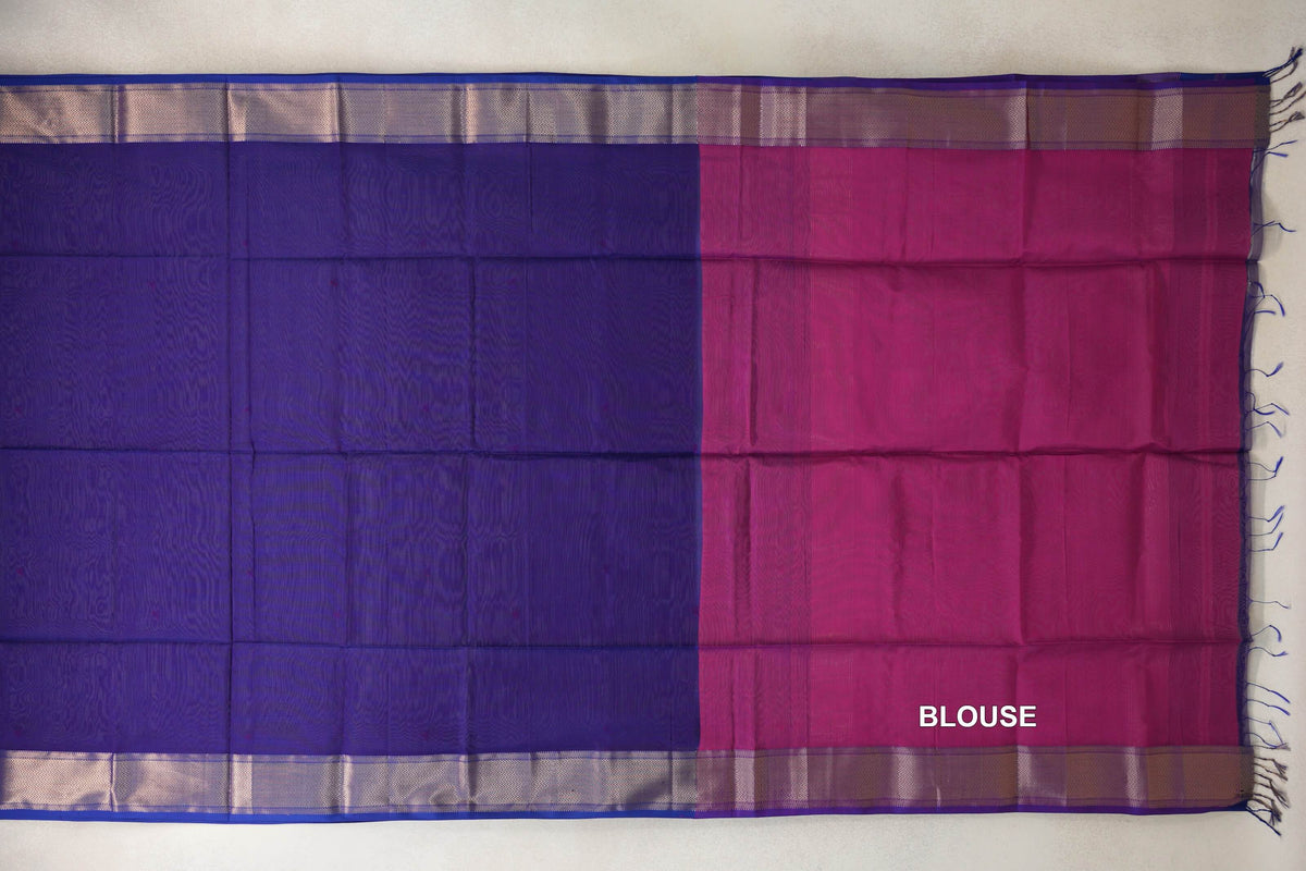 Saree laid flat with a deep violet silk cotton body, deep rani pink blouse section, zigzag-patterned borders and tassels at the end.
