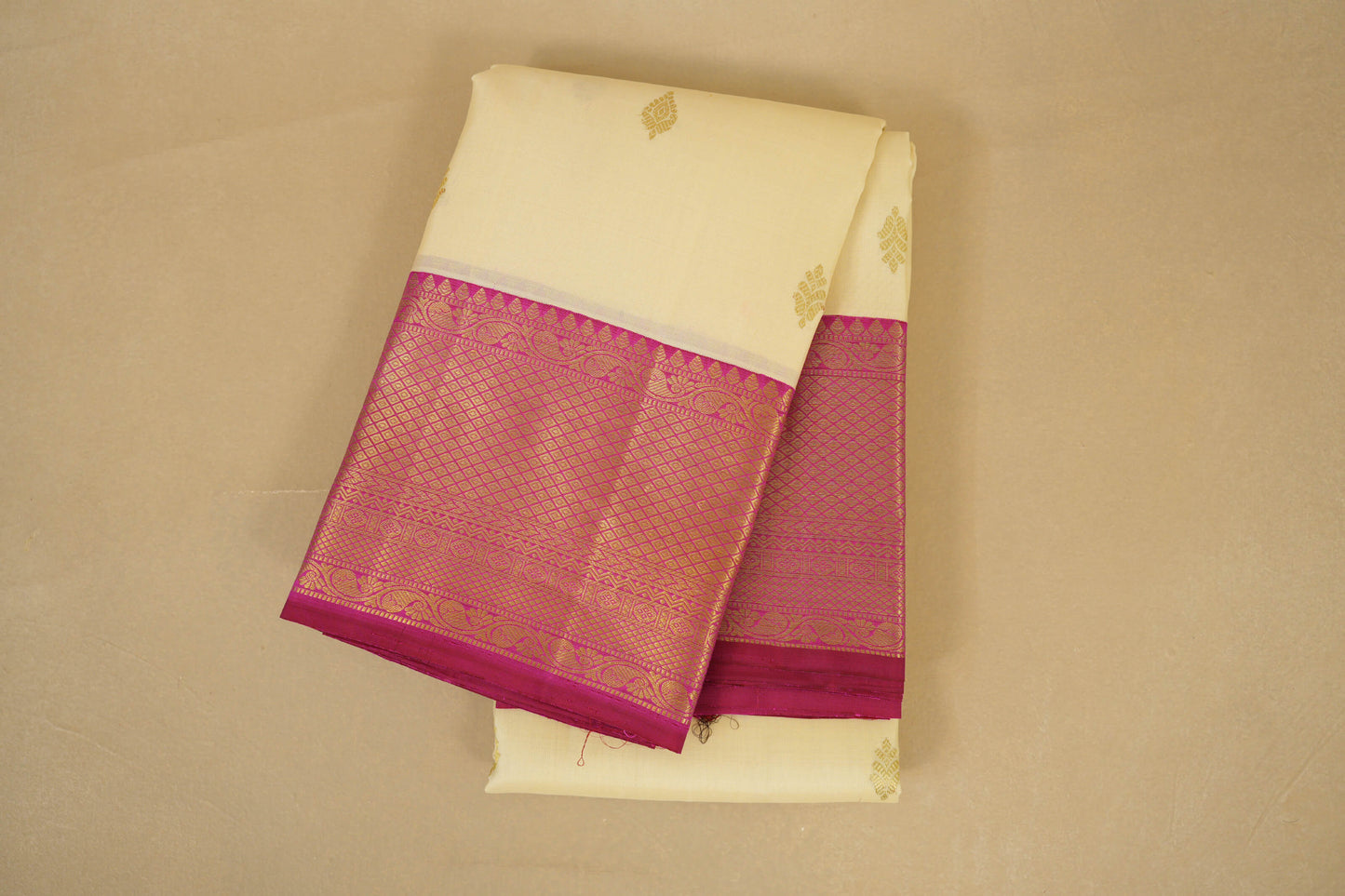 Folded saree with a white body and pink border kanjivaram silk saree