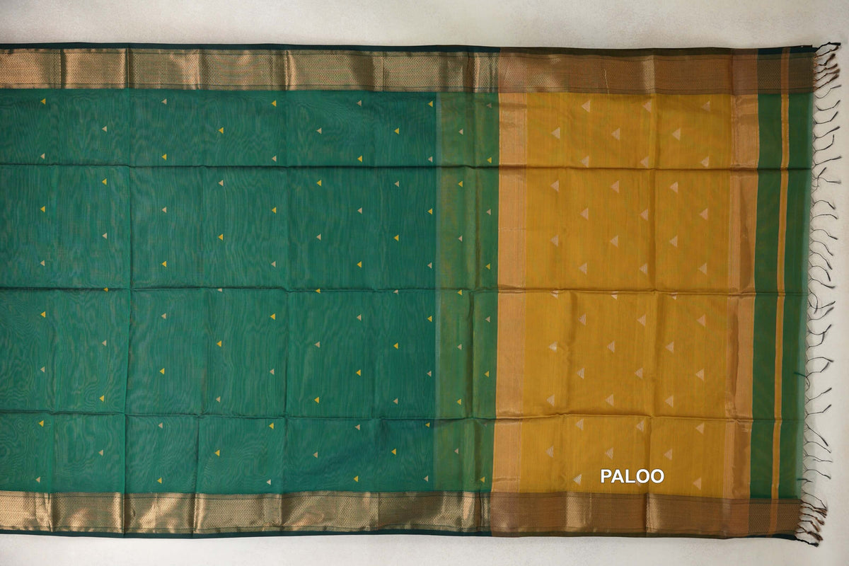 Bottle green Maheshwari silk cotton saree laid flat, with small triangle motifs, patterned borders and a mustard yellow pallu with tassels.