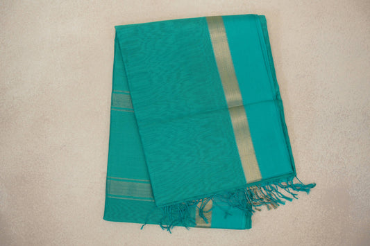 Folded bright aqua green Maheshwari silk cotton saree with a subtly textured body, gold-toned border stripe and tasselled edge.