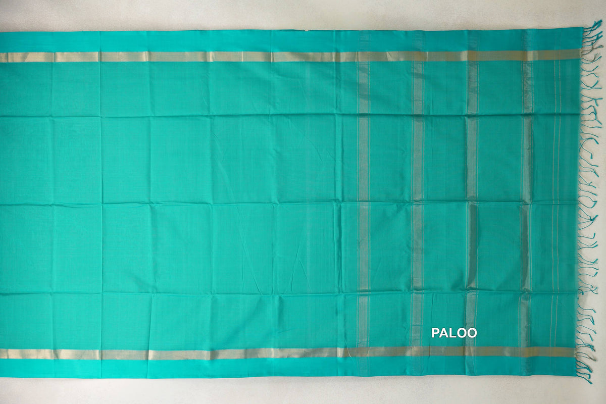 Bright aqua green Maheshwari silk cotton saree laid flat, with a plain body, pale gold-toned border bands and a striped pallu with tassels.
