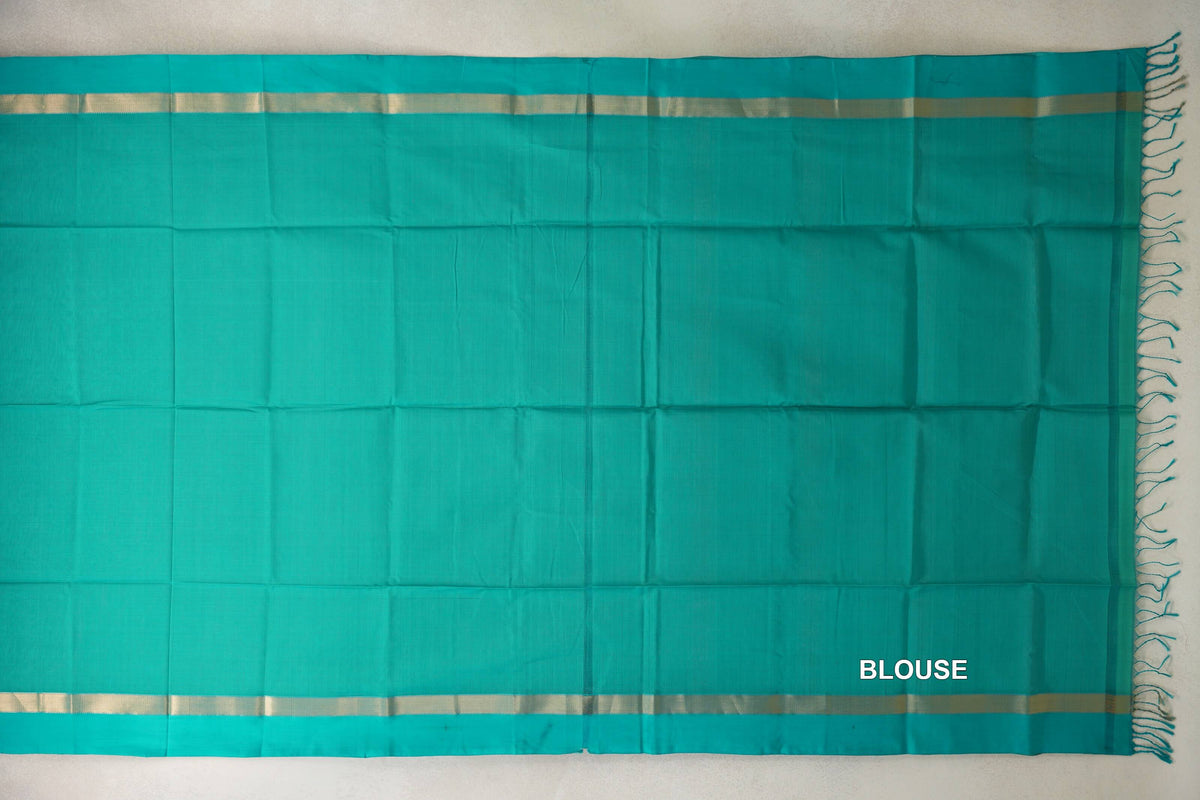 Bright aqua green Maheshwari silk cotton blouse fabric laid flat, with a plain body, narrow gold-toned stripes along both edges and tassels at one end.