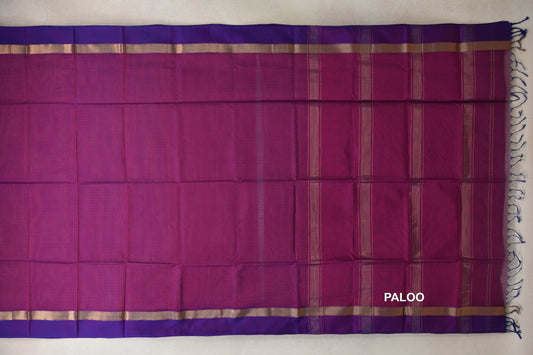 Spread-out pallu of a deep magenta Maheshwari silk cotton saree, with gold-toned stripes, violet purple borders and tassels at the end.