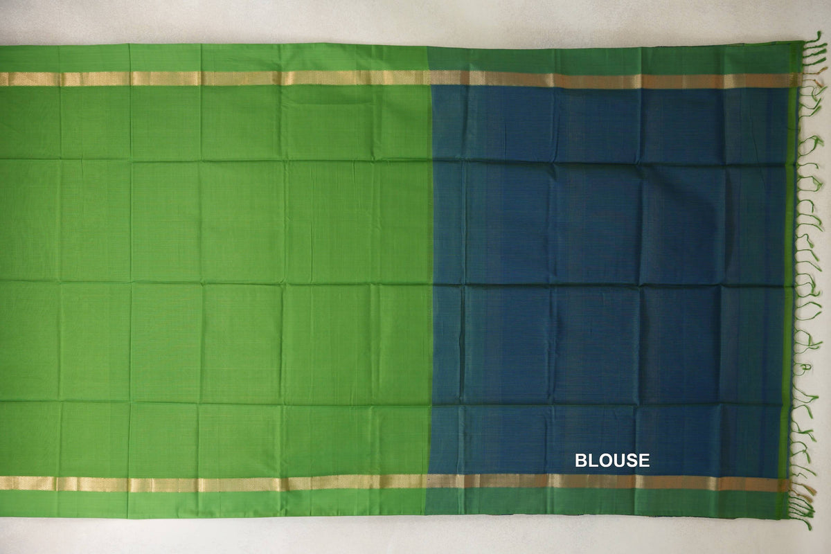 Unfolded Maheshwari silk cotton saree showing a bright leaf green body beside a peacock blue blouse section, with gold-toned borders and tassels.
