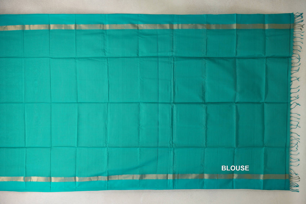 Bright Aqua Green Maheshwari silk-cotton saree laid flat, showing a plain body, slim gold-toned borders, tassels and a labelled blouse section.