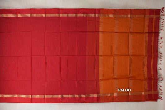 Red Maheshwari silk cotton saree laid flat, with a plain red body, orange pallu, narrow shimmering border stripes and tassels.
