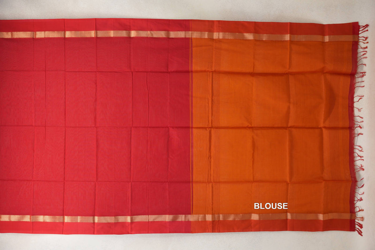 Red Maheshwari silk cotton saree laid flat beside its orange blouse piece, with red borders, narrow gold-toned stripes and tassels at one end.