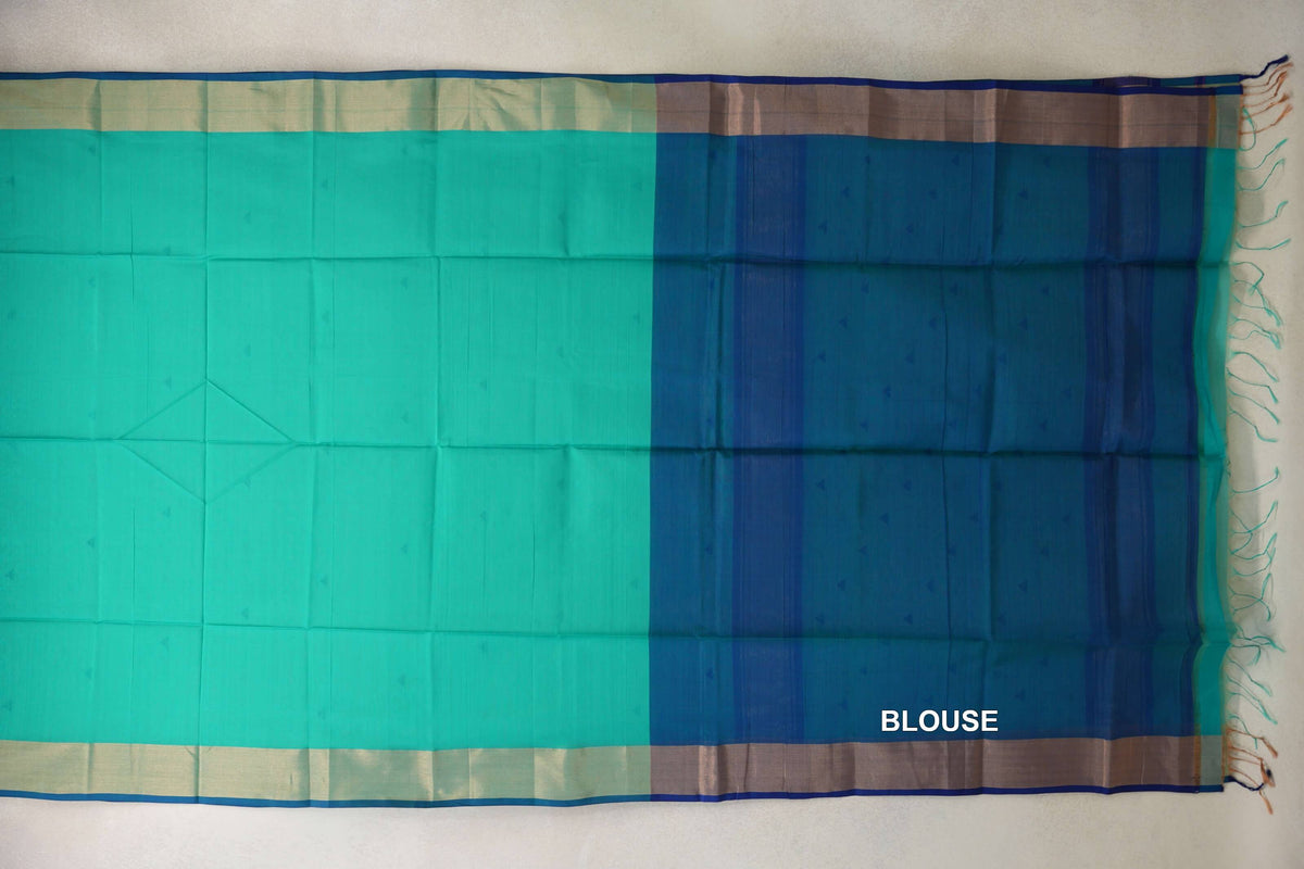 Sea green Maheshwari silk cotton saree spread flat, showing a classic blue blouse section, blue-edged borders and fringe at one end.