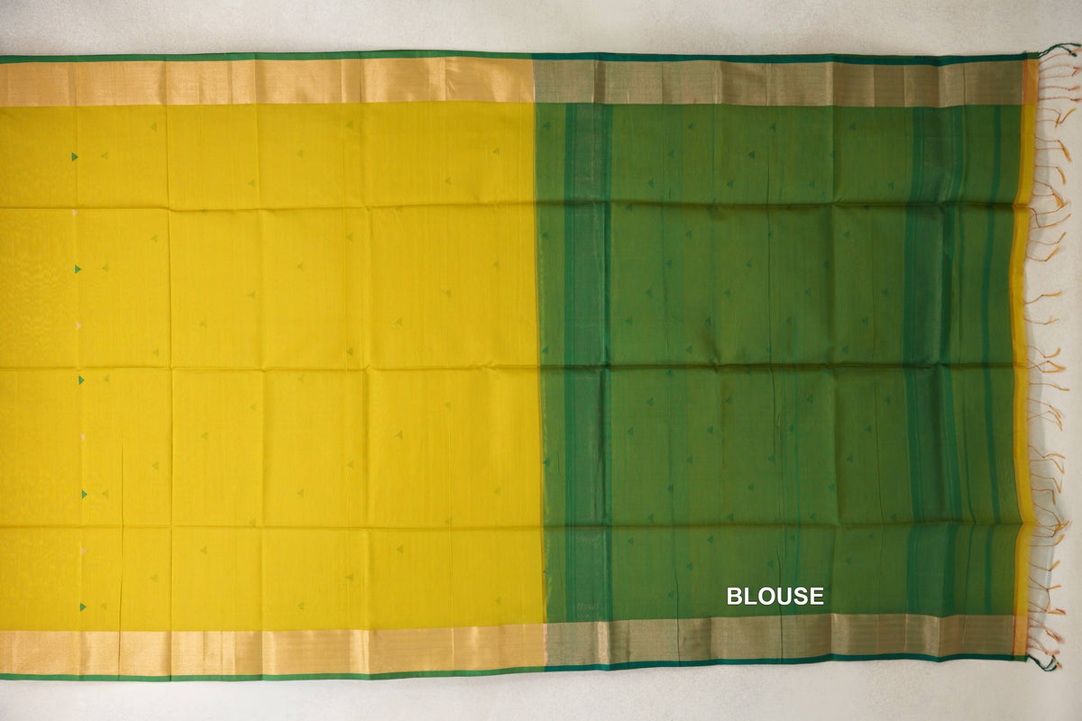 Maheshwari silk cotton saree laid flat, showing a bright lemon yellow body with small triangle motifs, gold-toned borders and a leaf green blouse section.