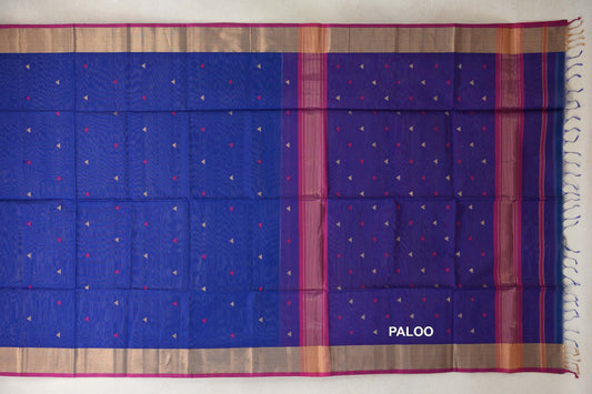 Maheshwari silk cotton saree laid open, showing a royal blue body and pallu with small triangular accents, rani pink-edged borders and tassels.