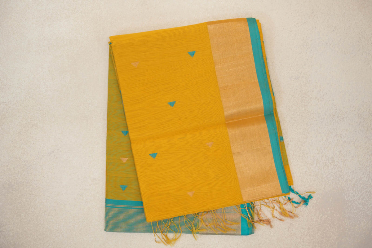 Folded Maheshwari silk-cotton saree with a mustard yellow body, small turquoise and gold triangles, a broad gold-toned border, turquoise edging and tassels.