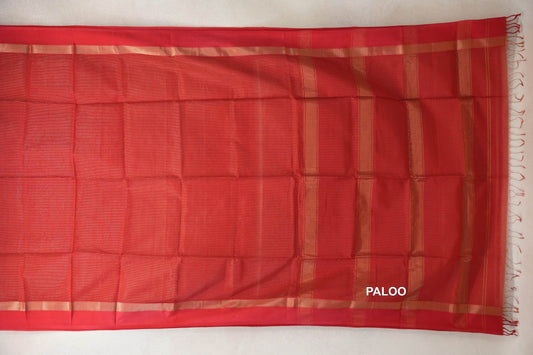 Tomato red Maheshwari silk cotton saree spread flat, showing a plain body, gold-toned border bands and a striped pallu with fringe.