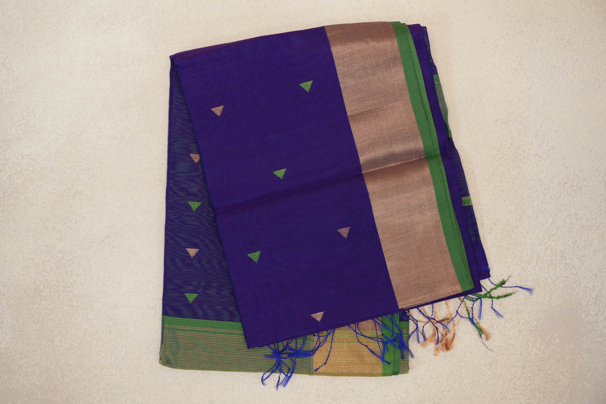 Folded deep violet Maheshwari silk cotton saree with small green and tan triangles, a broad tan border, green selvedge and tassels.