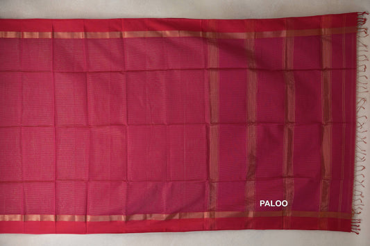 Rani Pink Maheshwari silk cotton saree laid flat, showing a plain body, gold-toned border bands and a striped pallu with tassels.