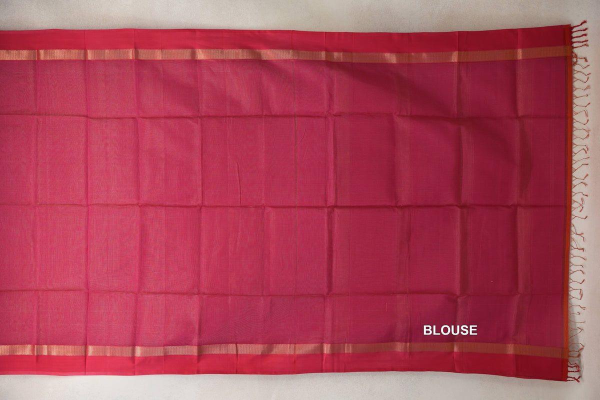 Rani Pink Maheshwari silk cotton blouse piece laid flat, with narrow gold-toned stripes along the edges and tassels at one end.