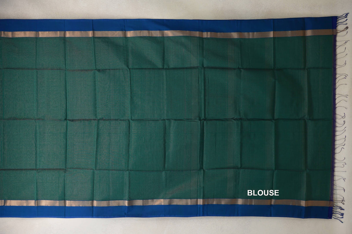 Bottle green blouse piece for a Maheshwari silk-cotton saree, laid flat with peacock blue borders, narrow metallic bands and fringes at one end.