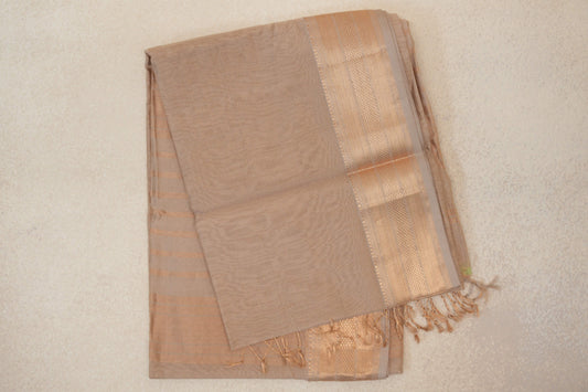 Folded Dark Sandal Beige Maheshwari silk cotton saree with a plain body, lustrous patterned border, fine stripes and tasselled edge.