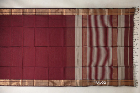 Maroon Maheshwari silk cotton saree laid flat, with patterned borders and a grey-and-maroon striped pallu ending in tassels.