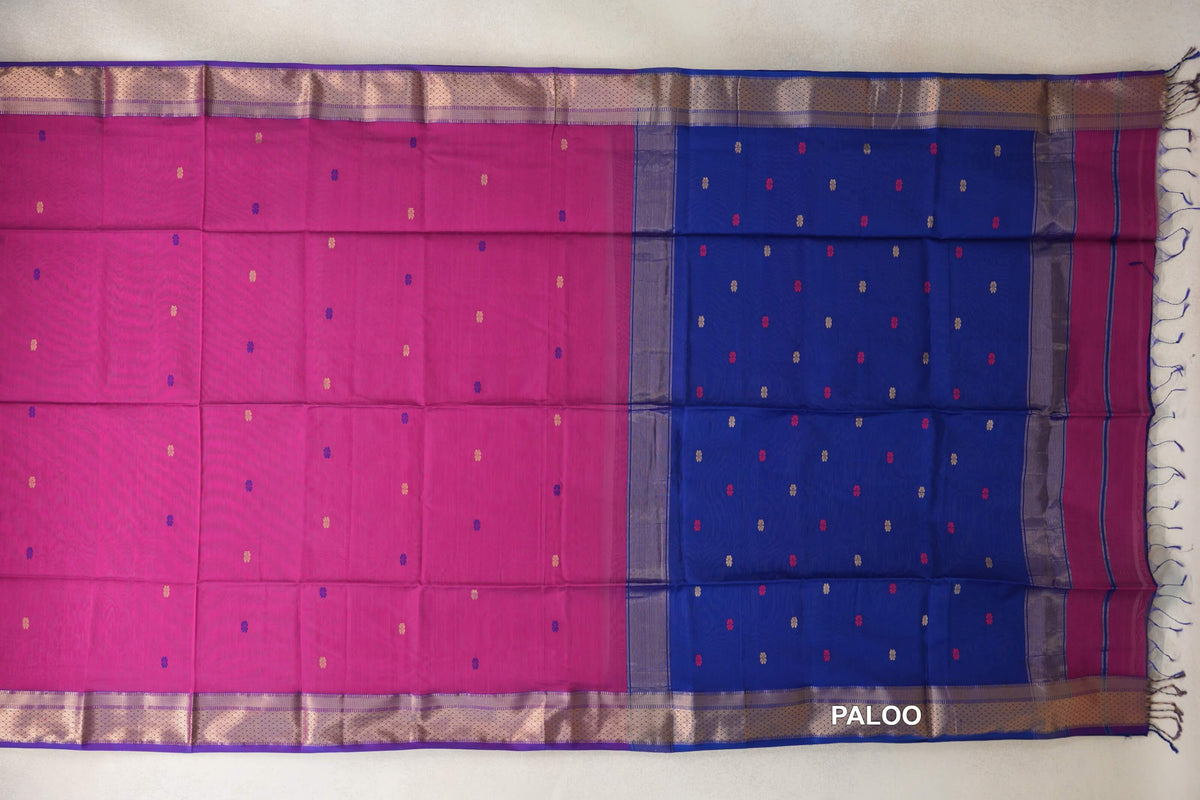 Maheshwari silk cotton saree spread flat, showing a bright rani pink body, royal blue pallu, scattered small accents and patterned royal purple borders.